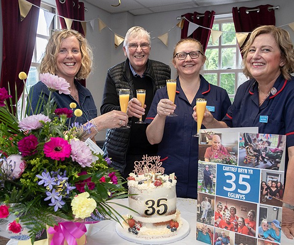 Meryl, Gabi and the team celebrating 35 years with a card, cake, and flowers!