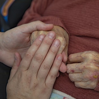 Caring hand holding at Cartref Bryn yr Eglwys