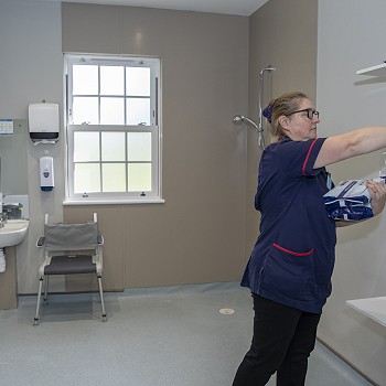One of the team sorting equipment in a bathroom at Cartref Bryn yr Eglwys