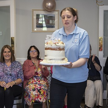 Staff member carrying the celebration cake