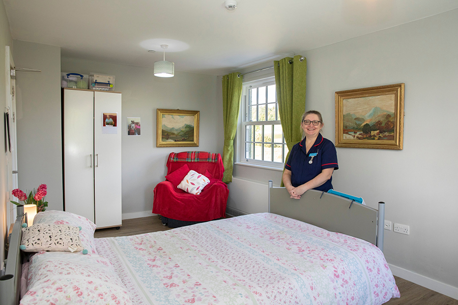 Gabi Sabadus next to a bed in a bedroom