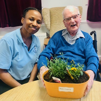 Mr Bernant Hughes (Ruthin) with his carer Mavis enjoying planting flowers