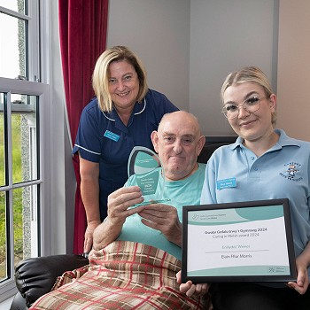 Cartref Bryn Yr Eglwys staff and resident celebrating Caring in Welsh Award